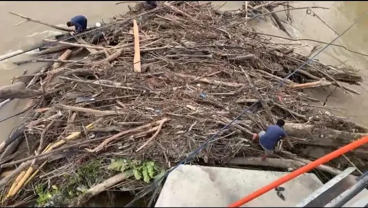 Antisipasi Kerusakan Infrastruktur, Dinas PUPR Rohul Bersihkan Kayu Tersangkut di Tiang Jembatan Ujungbatu