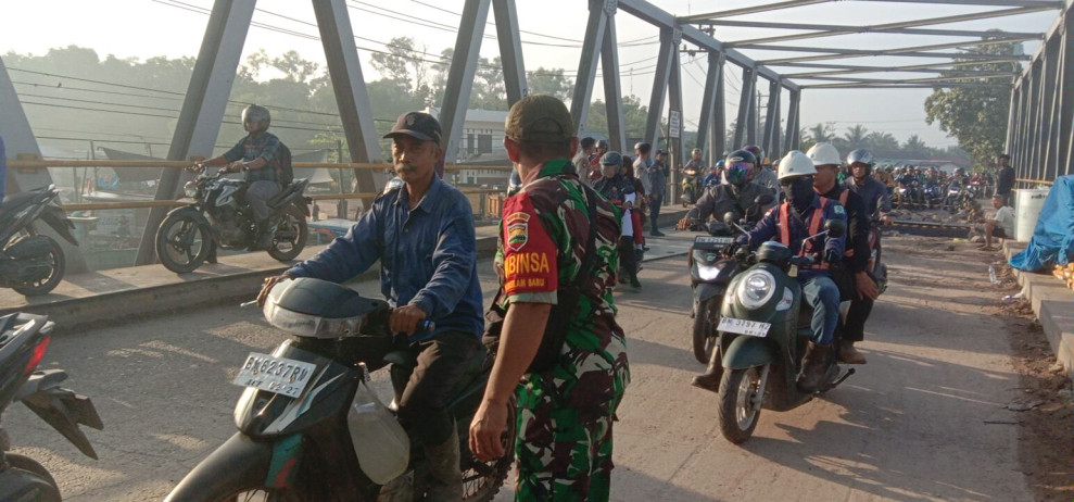 Babinsa Sertu Mahyudin dan Sertu Jainal Arifin Pastikan Arus Lalu Lintas di Jembatan Sungai Masjid Tetap Lancar